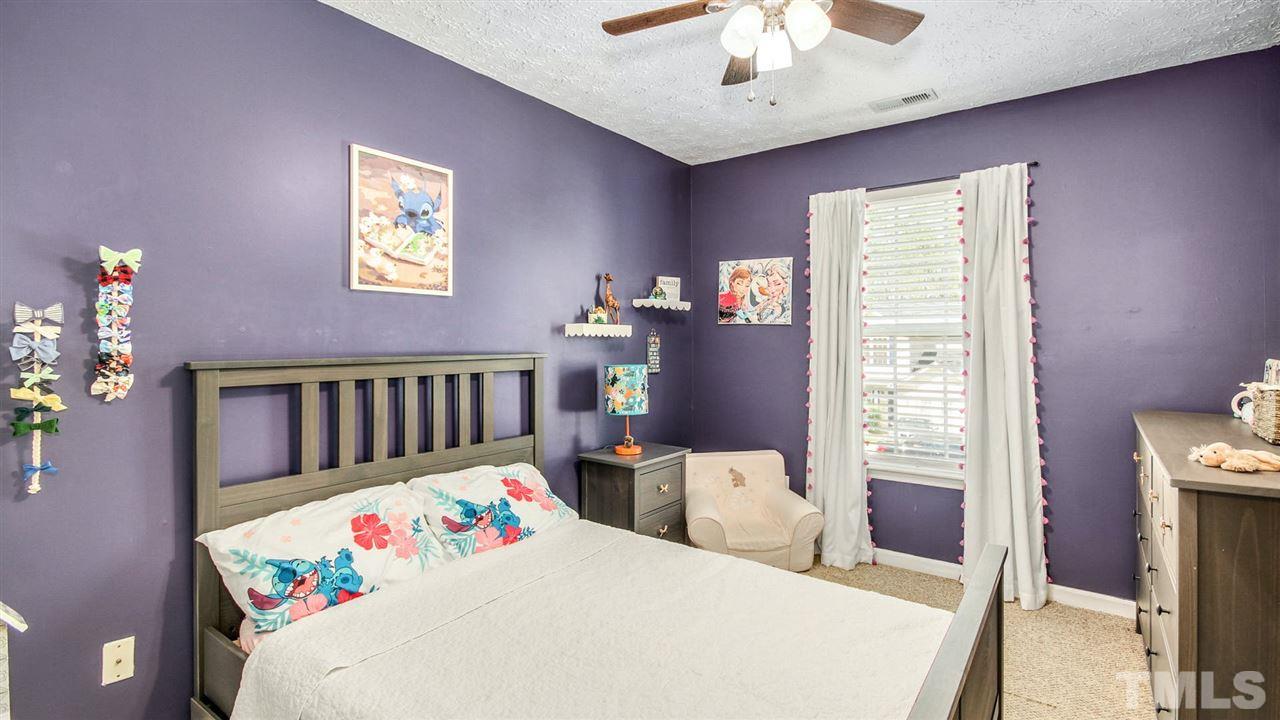 5720 Forest Point Road Raleigh, NC 27610 - Photo 16 of 22 a bedroom with a bed and a chandelier