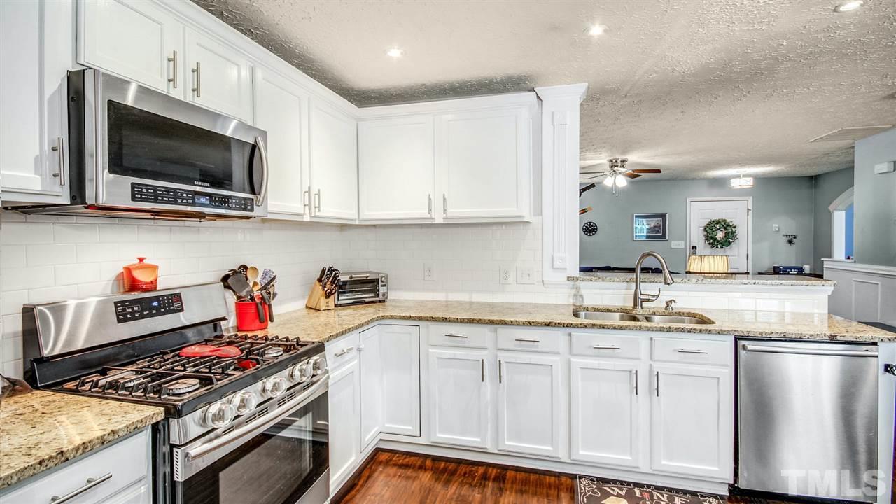 5720 Forest Point Road Raleigh, NC 27610 - Photo 9 of 22 a kitchen with stainless steel appliances granite countertop a sink and a stove