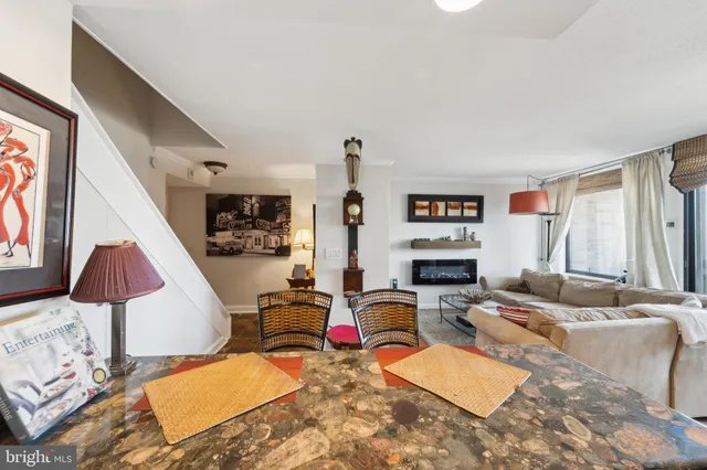 a living room with furniture kitchen view and a large window
