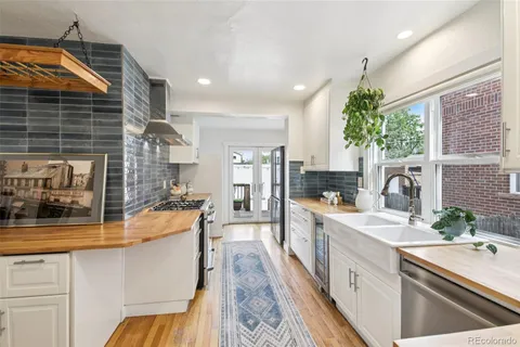 a large white kitchen with sink and refrigerator