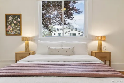 a bedroom with a bed and a painting on the wall