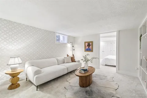 a living room with furniture a rug and a lamp