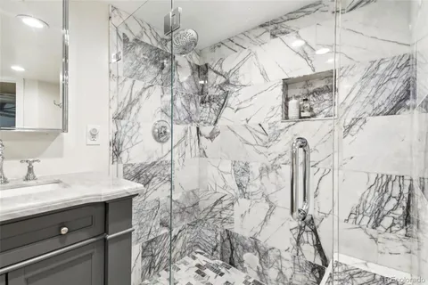 a bathroom with a sink and mirror with bathtub