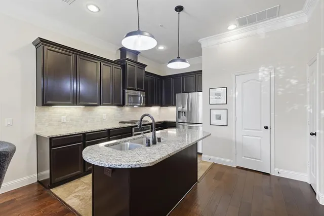 a kitchen with stainless steel appliances granite countertop a sink a refrigerator and a stove