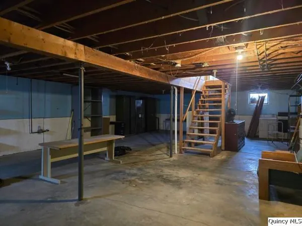 a view of an empty room with stairs and furniture