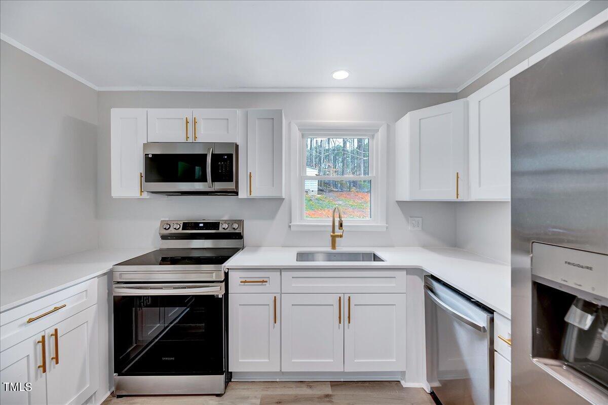 2808 Oak Ridge Court Raleigh, NC 27603 - Photo 13 of 43 a kitchen with white cabinets stainless steel appliances and sink