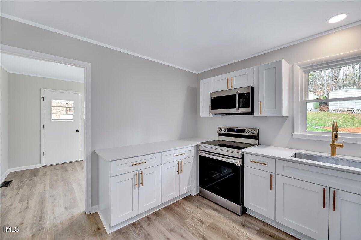 2808 Oak Ridge Court Raleigh, NC 27603 - Photo 15 of 43 a kitchen with white cabinets appliances and a window