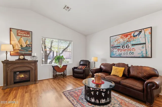 a living room with furniture a fireplace and a large window