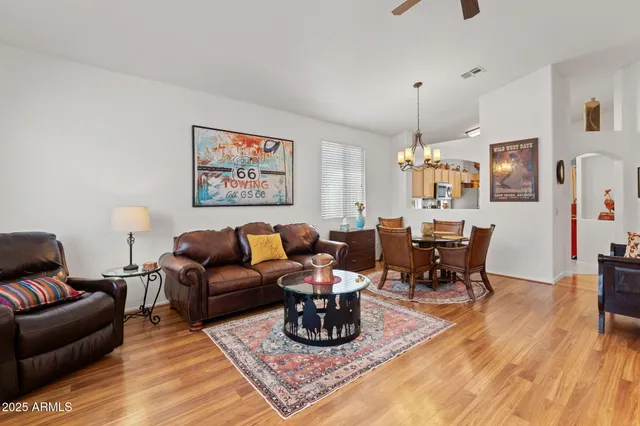 a living room with furniture a dining table and a chandelier