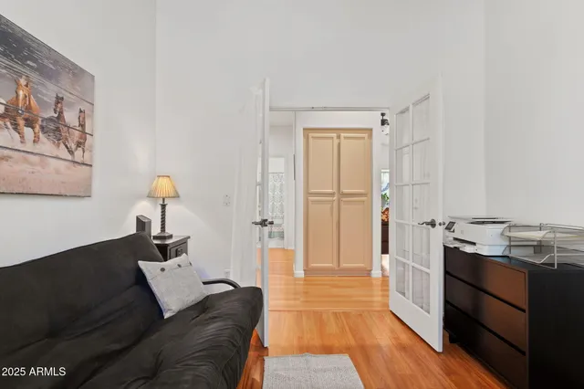 a living room with stainless steel appliances furniture a rug and a wooden floor