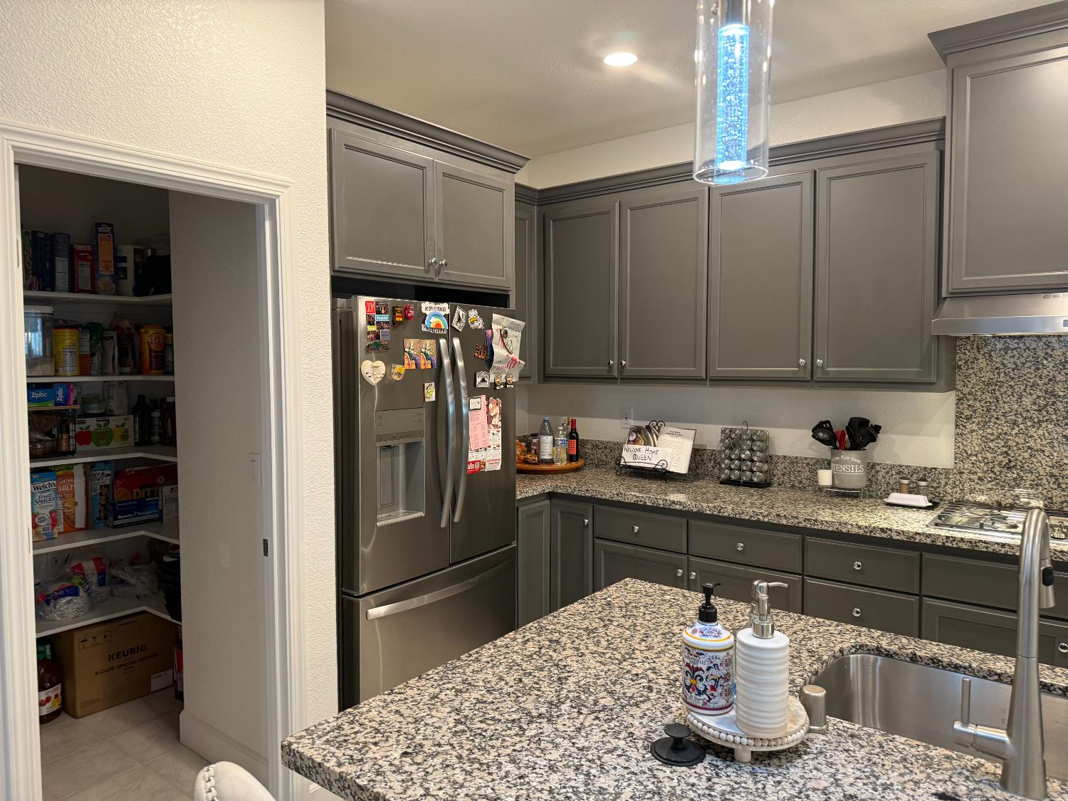 461 Walcott Street Manteca, CA 95336 - Photo 3 of 24 a kitchen with granite countertop a refrigerator and cabinets