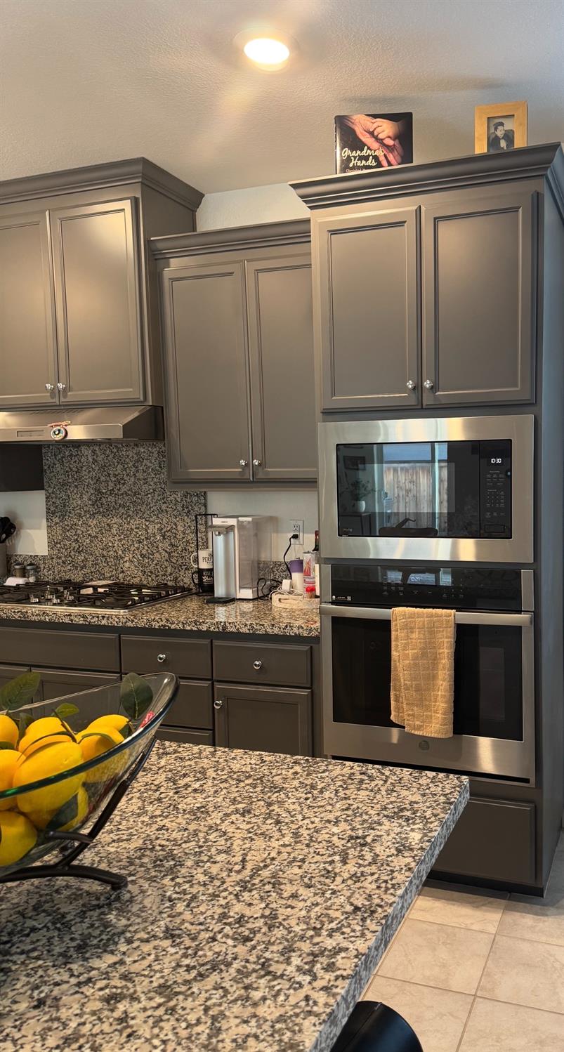 461 Walcott Street Manteca, CA 95336 - Photo 4 of 24 a kitchen with stainless steel appliances granite countertop a stove a sink and a microwave