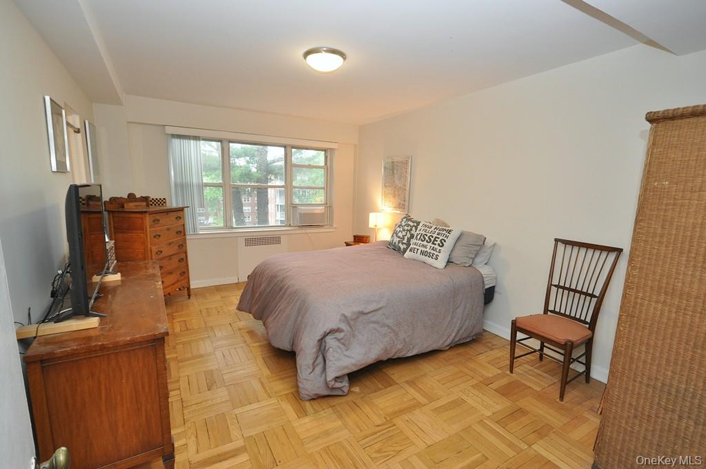 235 Garth Road, Unit A5B Scarsdale, NY 10583 - Photo 17 of 47 a spacious bedroom with a bed and a chair