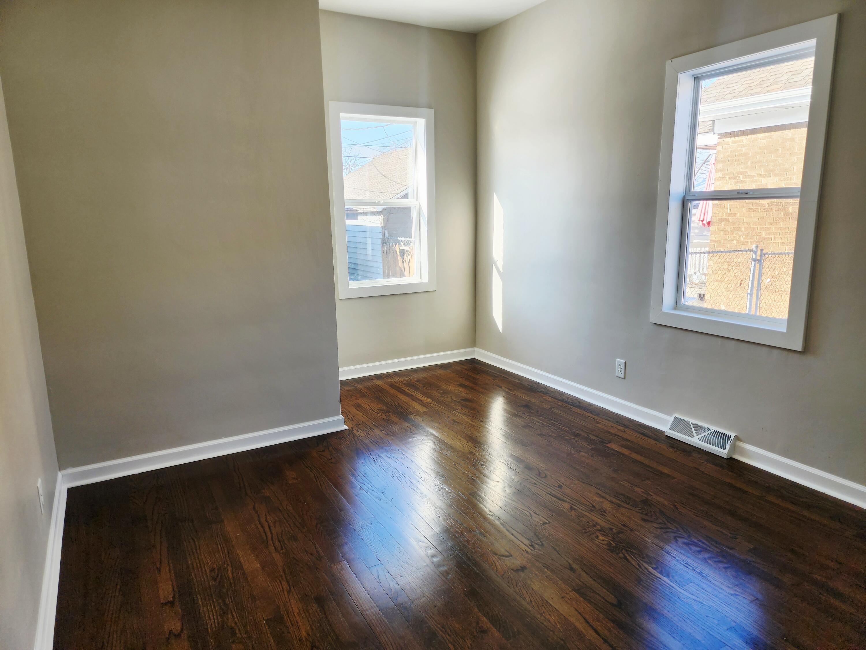 418 Taft Street Gary, IN 46404 - Photo 11 of 18 an empty room with wooden floor and windows