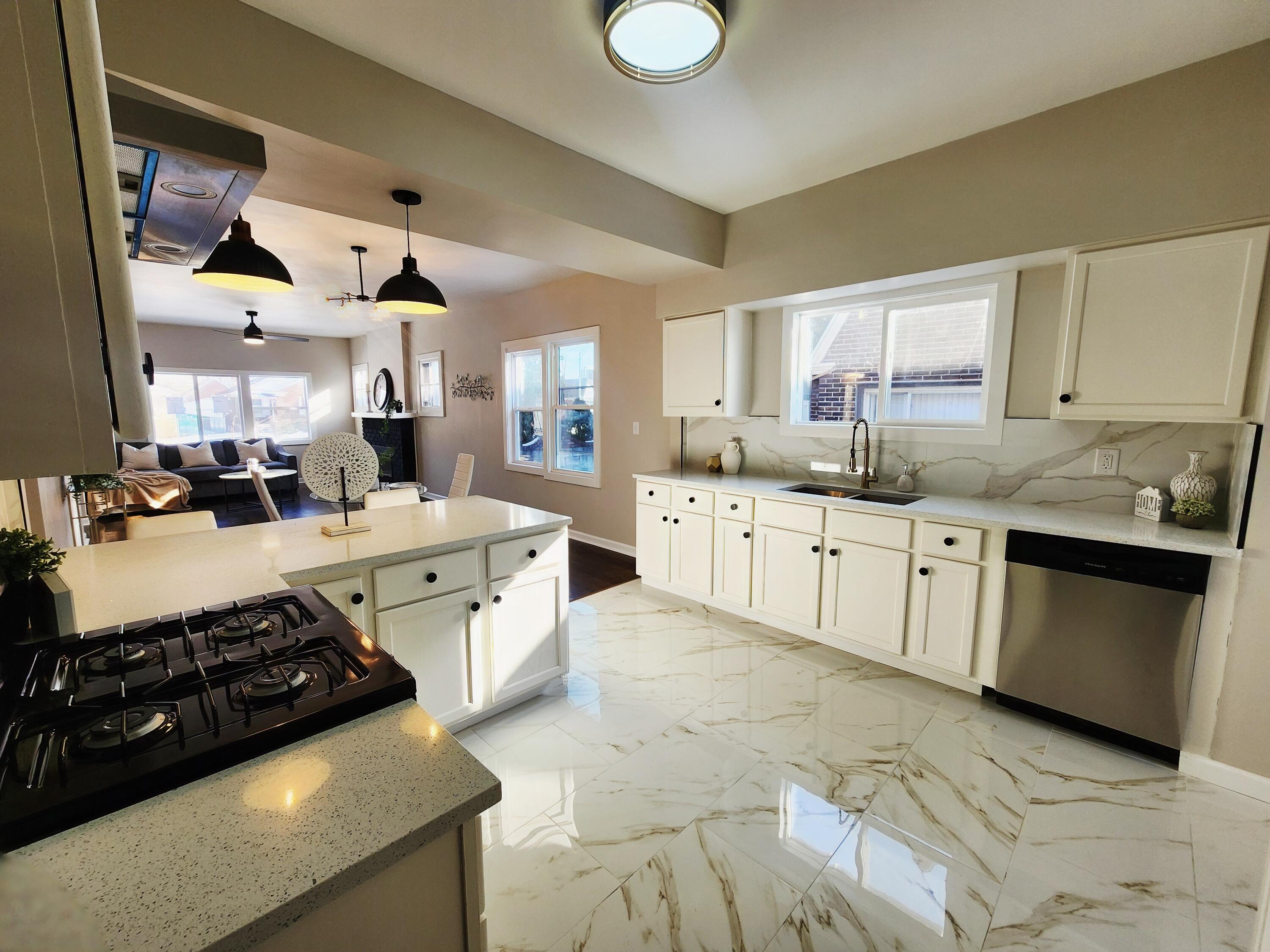 418 Taft Street Gary, IN 46404 - Photo 8 of 18 a kitchen with stainless steel appliances a sink dishwasher stove and white cabinets