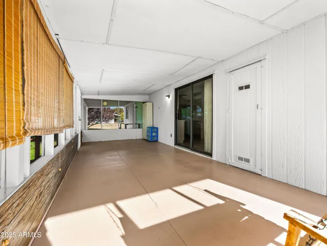 a view of a hallway with wooden floor and a living room