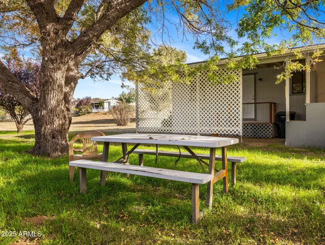 a view of sitting area in front of house with wooden fence