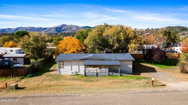 a front view of a house with a yard and mountain view