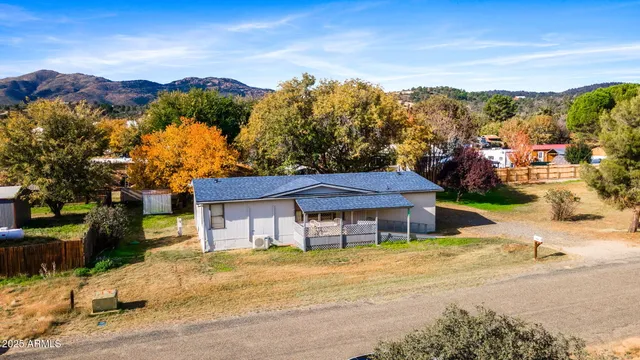 a front view of a house with a yard and mountain view