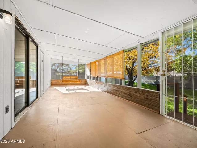 a view of an empty room with wooden floor and windows