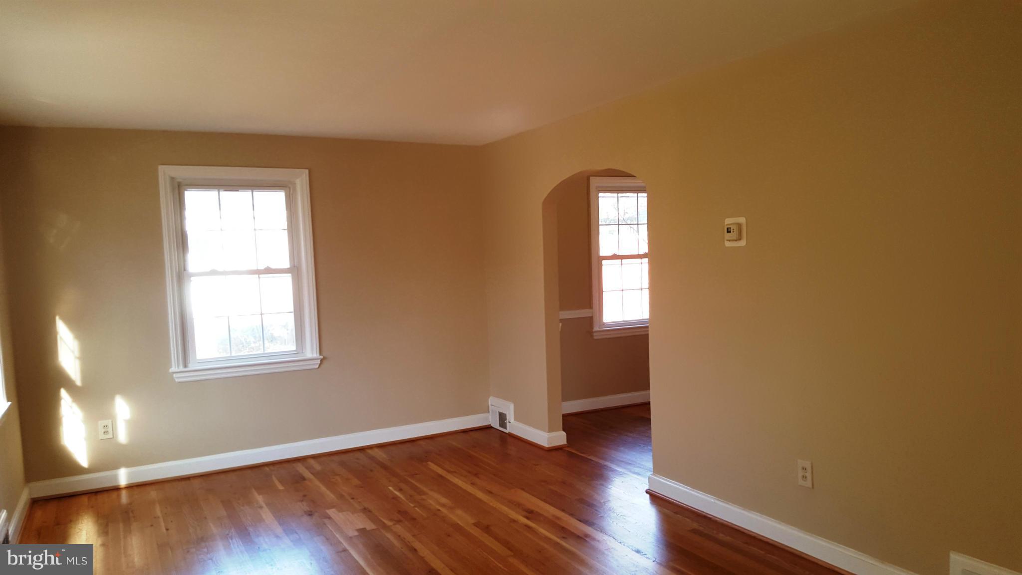 9011 Eton Road Silver Spring, MD 20901 - Photo 2 of 13 an empty room with wooden floor and windows