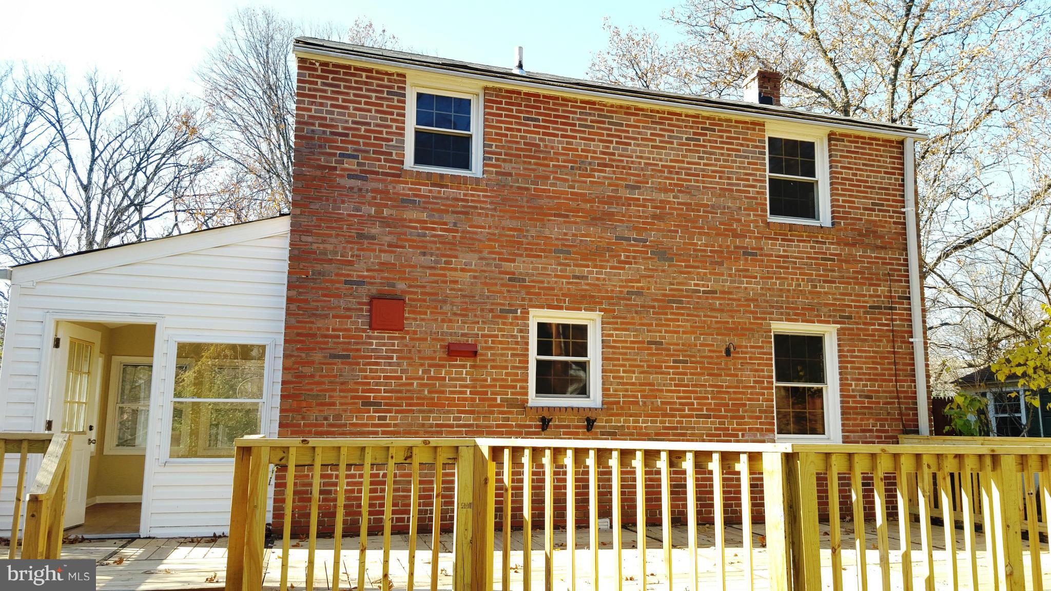 9011 Eton Road Silver Spring, MD 20901 - Photo 12 of 13 a brick house next to a yard