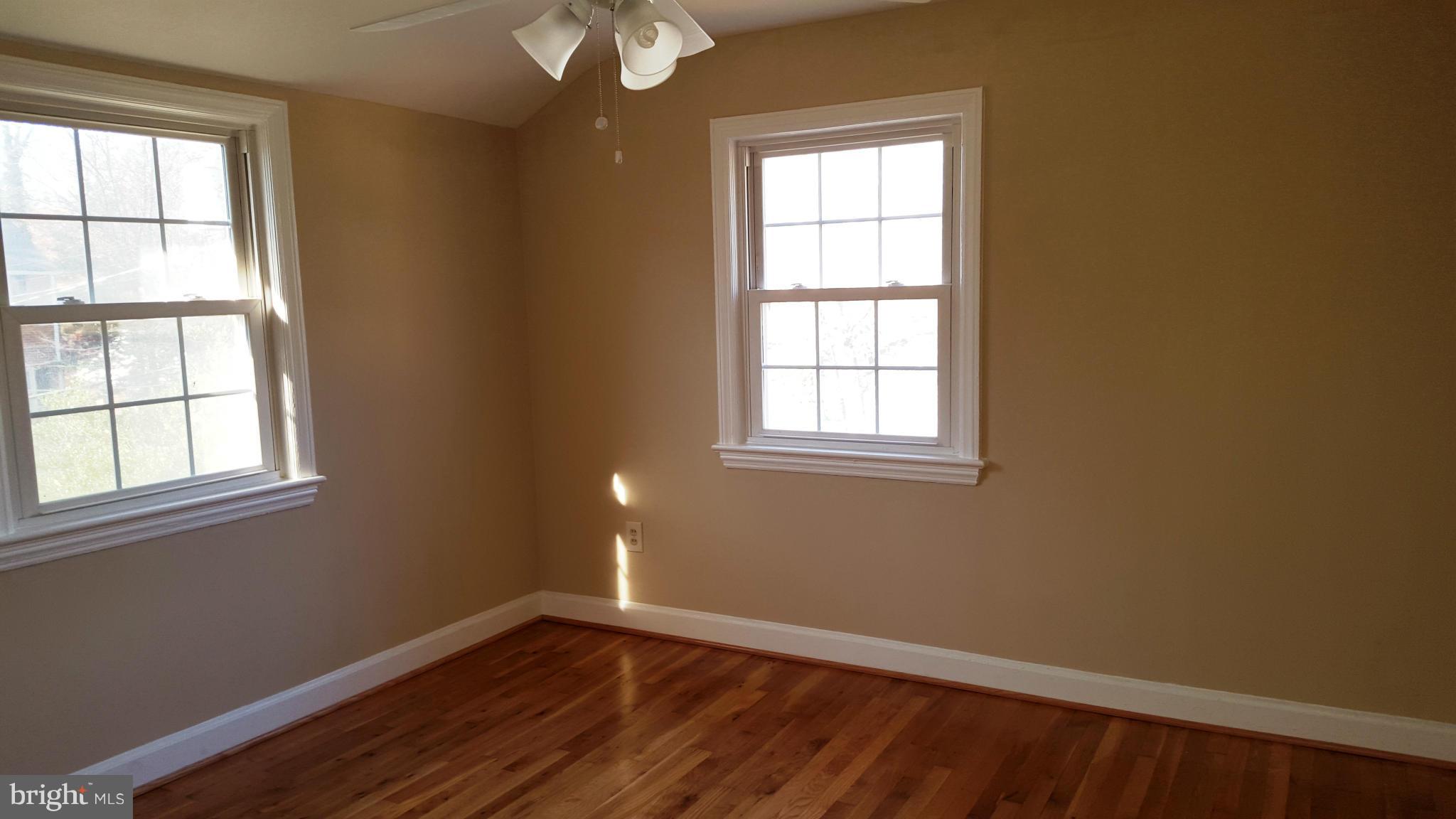 9011 Eton Road Silver Spring, MD 20901 - Photo 7 of 13 an empty room with wooden floor and windows