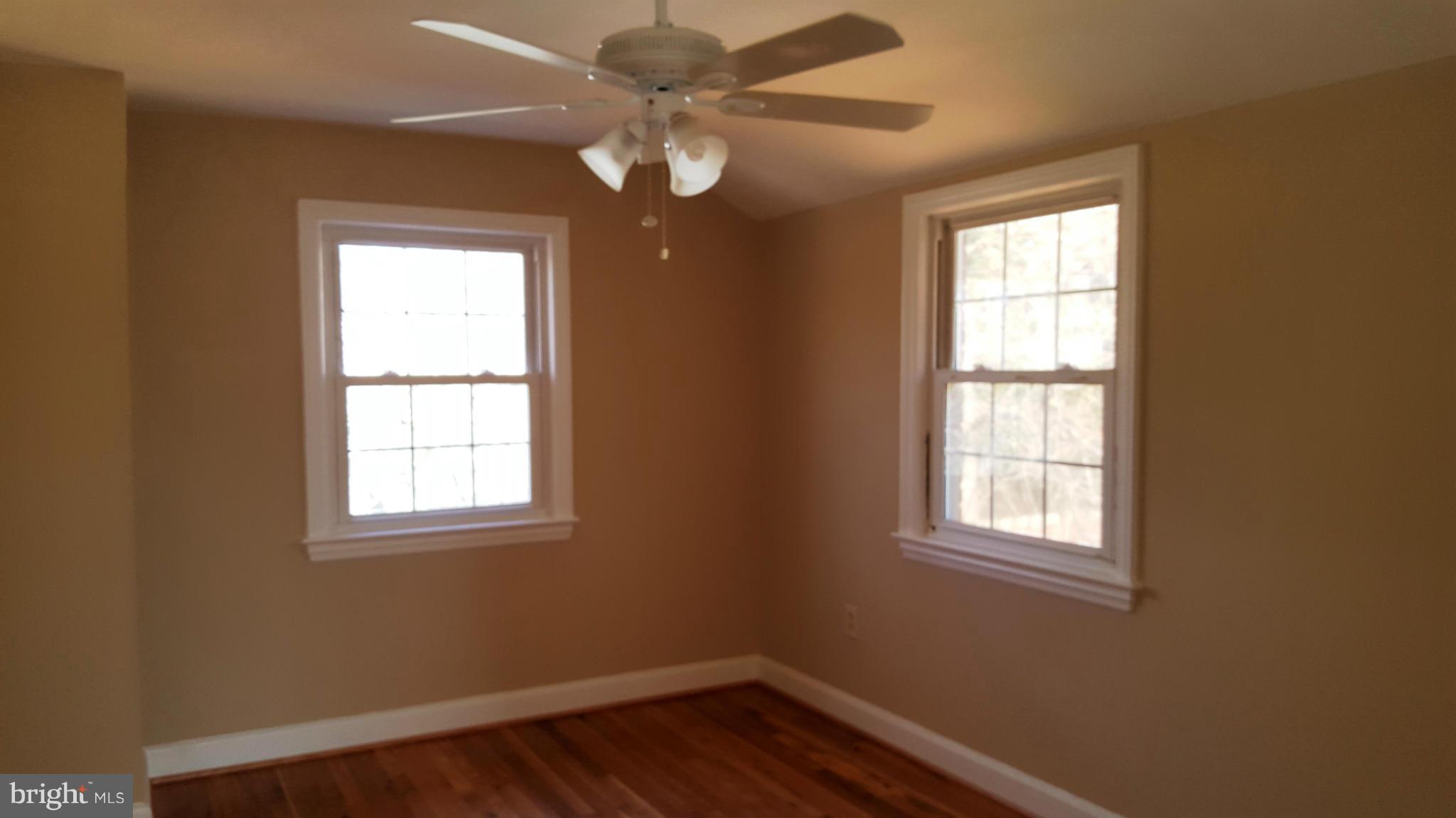 9011 Eton Road Silver Spring, MD 20901 - Photo 8 of 13 an empty room with windows and fan