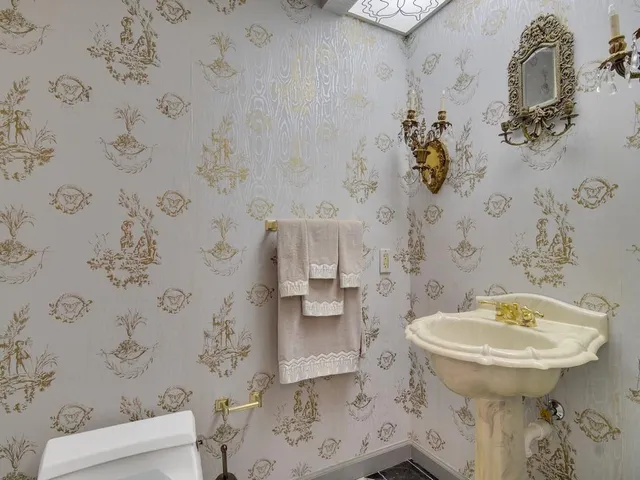 a bathroom with a sink toilet and a mirror