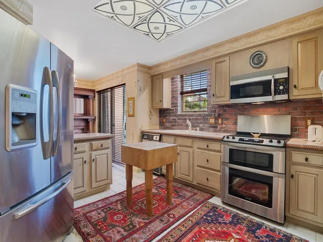 a kitchen with stainless steel appliances granite countertop a stove a sink cabinets and a dining table