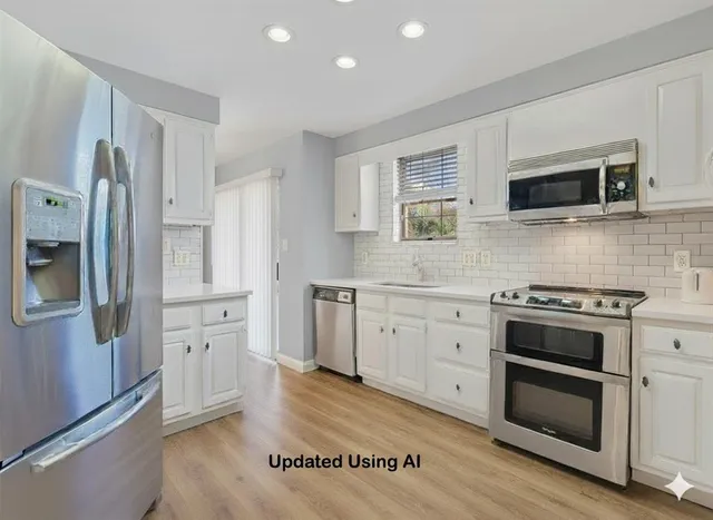 a kitchen with stainless steel appliances white cabinets and wooden floor
