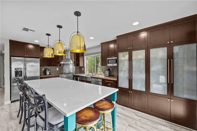 a kitchen with stainless steel appliances a dining table chairs and chandelier