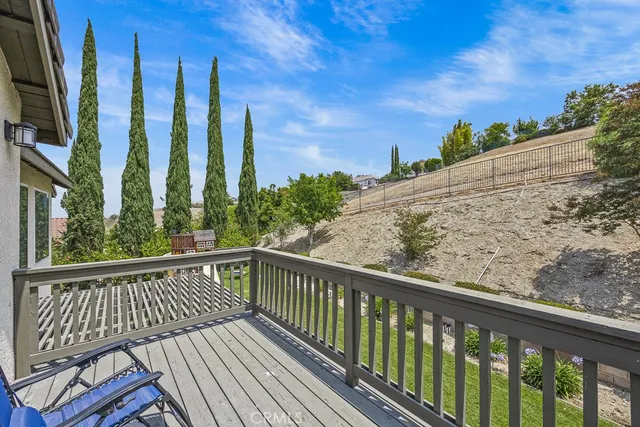 a view of a balcony with wooden floor and fence