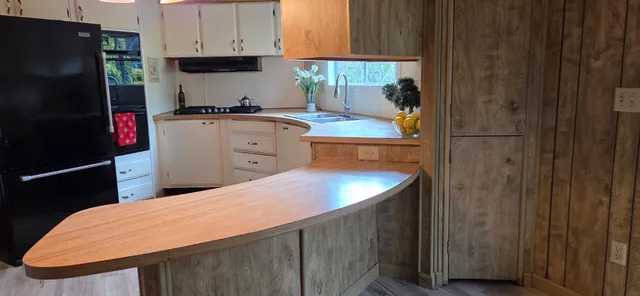 a kitchen with a sink a refrigerator and cabinets