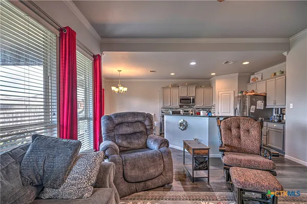 a living room with furniture and a view of kitchen
