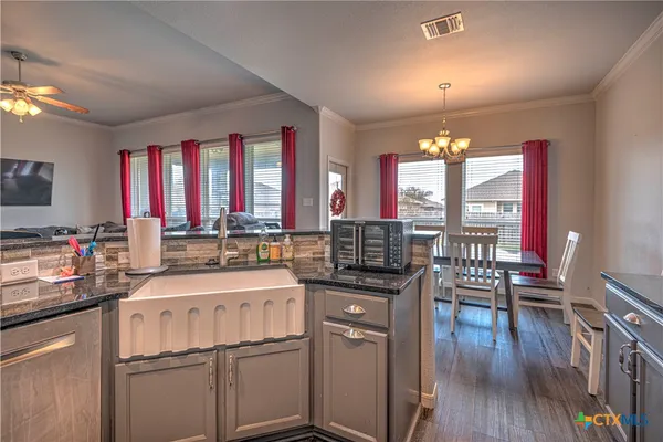 a kitchen with a sink stove and wooden floor