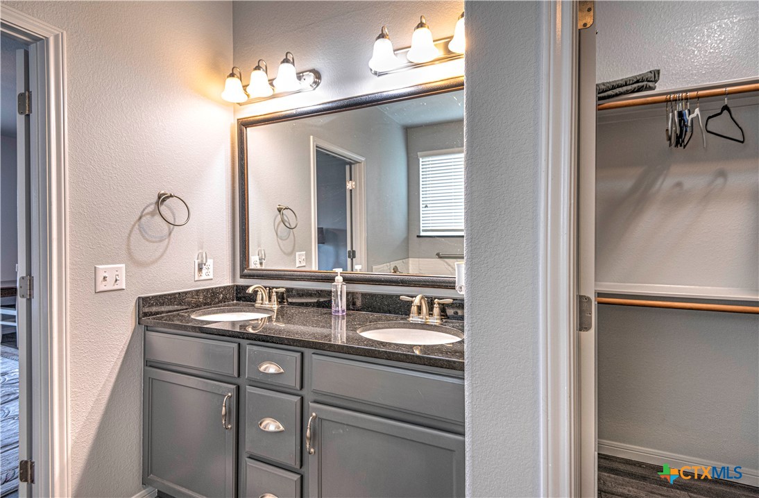504 Coventry Drive Temple, TX 76502 - Photo 23 of 30 a bathroom with a granite countertop sink and a mirror