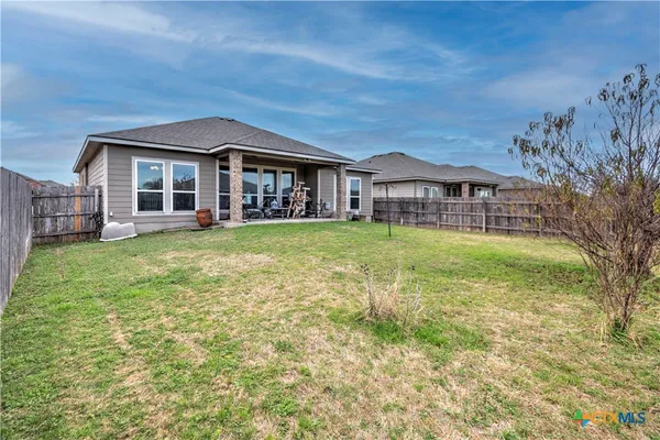 a view of a house with a big yard and large trees