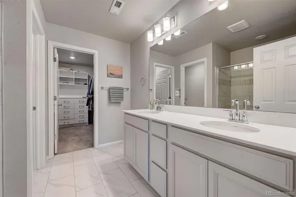 a spacious bathroom with a shower a sink and a mirror