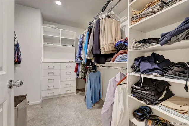 a view of walk in closet with clothes and shoes