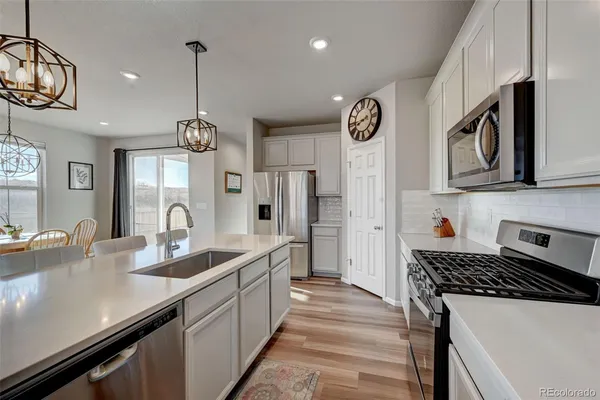 a kitchen with stainless steel appliances a sink a stove and cabinets