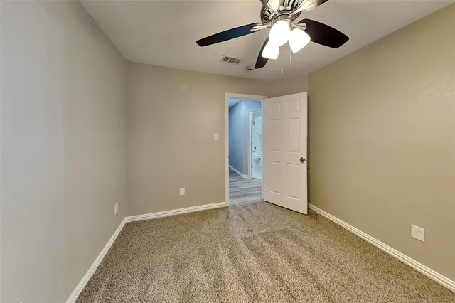 an empty room and chandelier fan