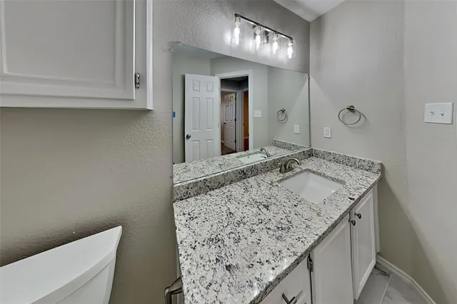 a bathroom with a granite countertop sink and a mirror