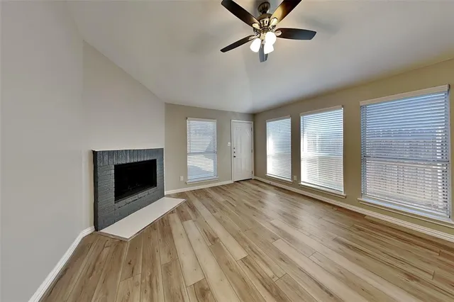 a view of an empty room with a fireplace and a window