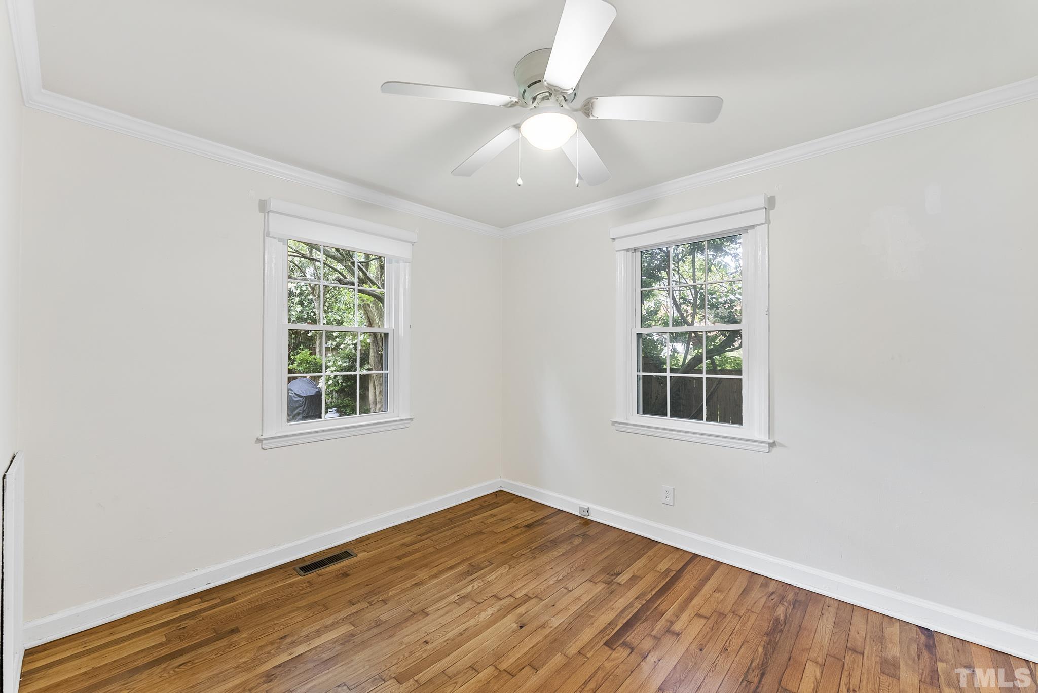 808 Young Street Raleigh, NC 27608 - Photo 15 of 26 an empty room with wooden floor and windows