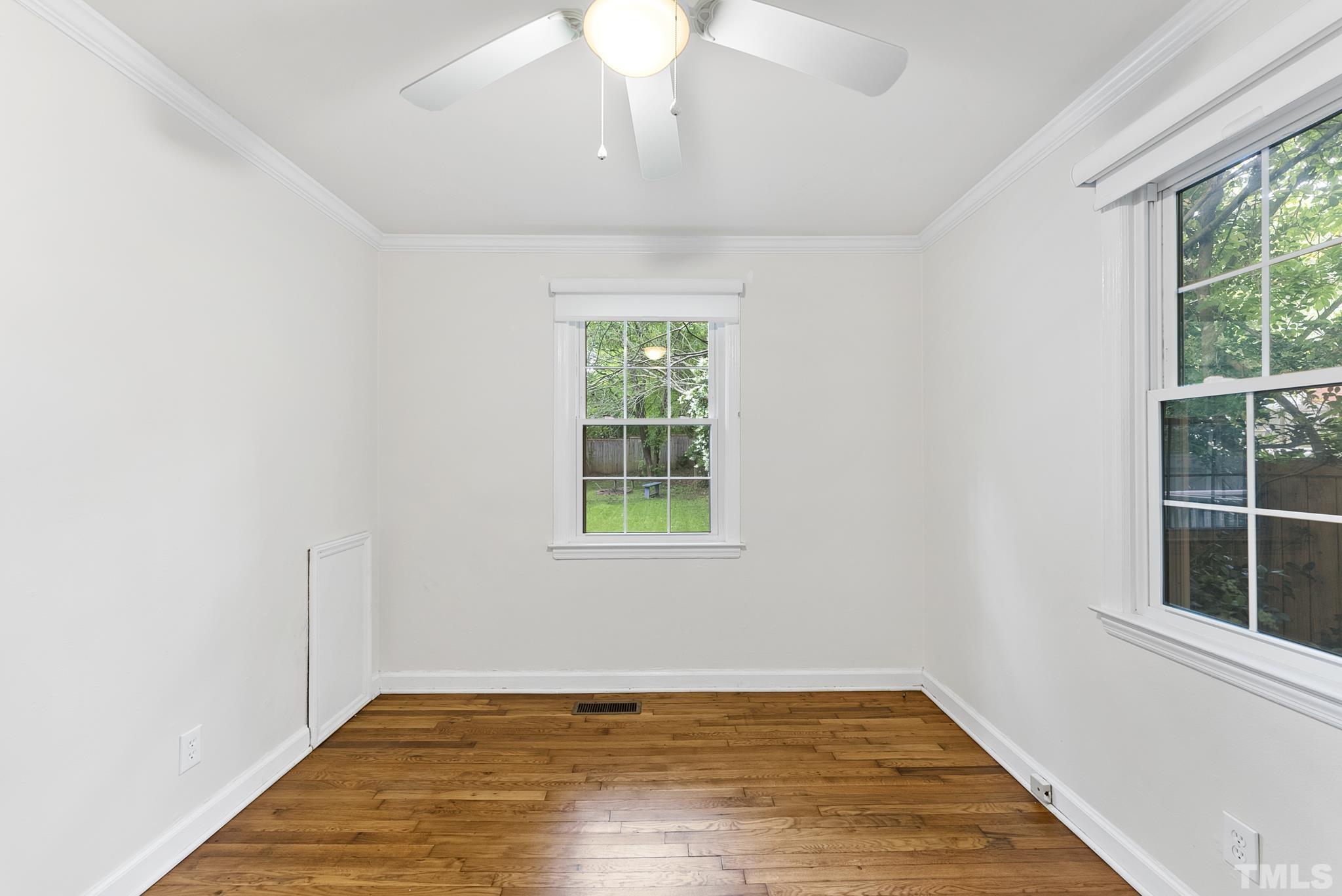 808 Young Street Raleigh, NC 27608 - Photo 16 of 26 an empty room with wooden floor and windows
