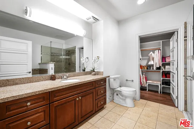 a spacious bathroom with a granite countertop sink a toilet and a mirror