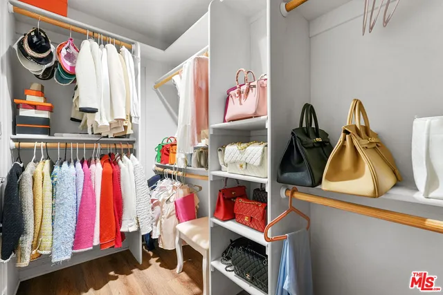 a view of walk in closet with clothes and shoes