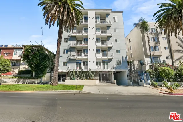 a view of a tall building next to a yard