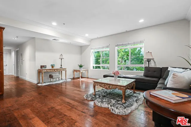 a living room with furniture and a table with wooden floor